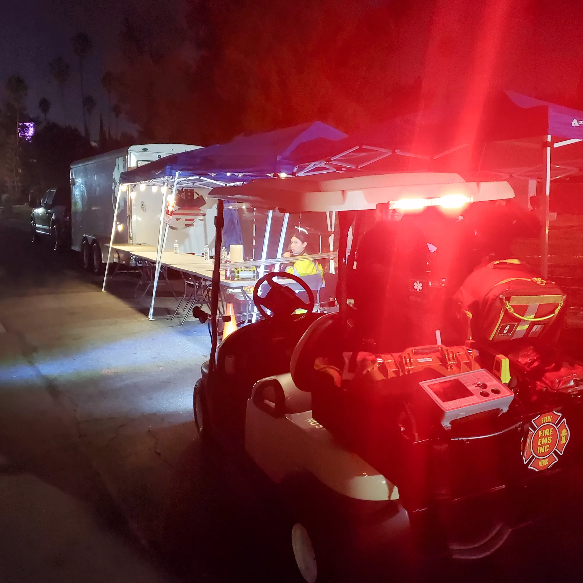 A medical cart with red lights at night.